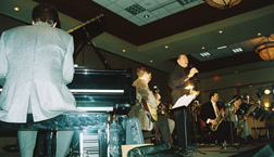 Gates with pianist Tom Harvill, guitarist Pete Bouffard and the brass [Photo by Tom Ineck]